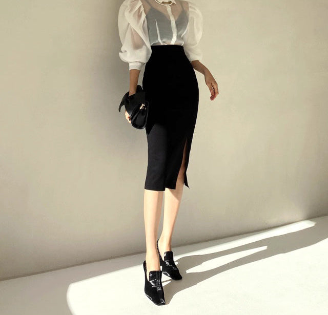 Woman wearing Orchid Moda chic sheer office blouse with puff sleeves and black pencil skirt with front slit