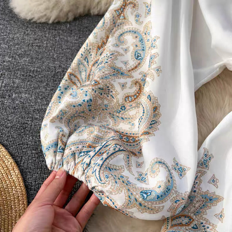 Close-up of sleeve detail on floral paisley mini dress with blue and beige patterns