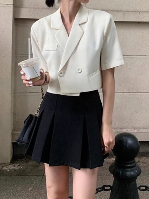 Orchid Moda formal open back top in white with short sleeves paired with black pleated skirt