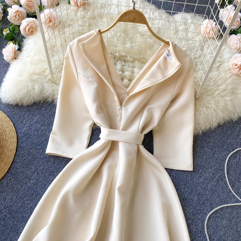 Orchid Moda almondine midi dress in cream with long sleeves and a belted waist on a hanger