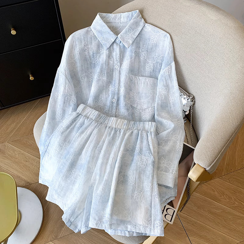 Light blue summer co-ord suit for women with floral patterns by Orchid Moda displayed on beige chair