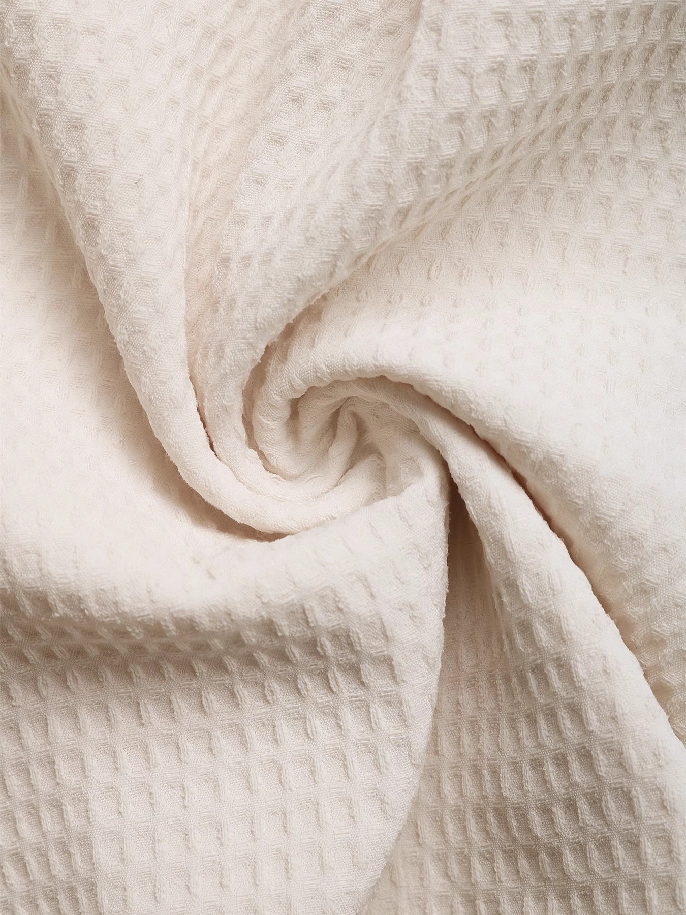 Close-up of cream textured fabric suitable for tasseled jumpsuit for women by Orchid Moda