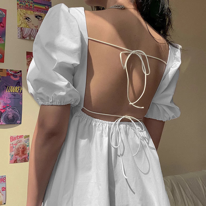 Orchid Moda white backless dress with puff sleeves and tie details on the open back