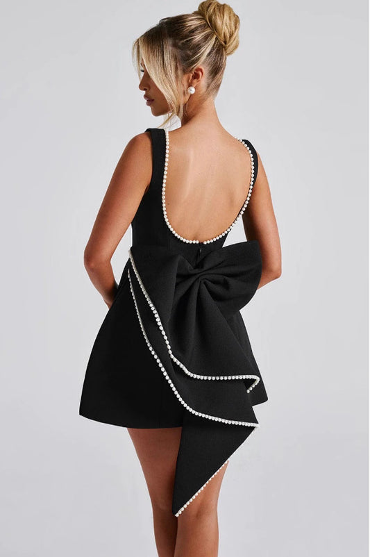 Back view of Bellara cocktail party dress by Orchid Moda with pearl trim and large bow detail in black