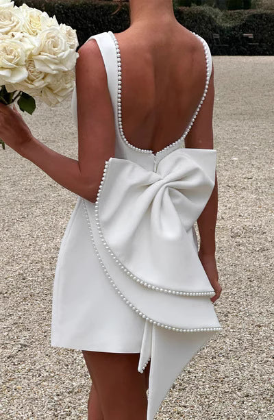 Back view of Bellara cocktail party dress by Orchid Moda featuring low scoop back and large decorative bow with pearl trim