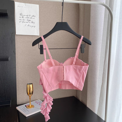 Orchid Moda blush corset top with adjustable straps and ruffle detail hanging on black hanger