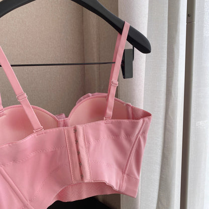 Orchid Moda blush corset top with adjustable straps hanging on black hanger indoors