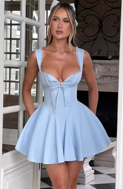 Woman wearing a cute mini dress for parties in light blue with a fitted bodice and flared skirt