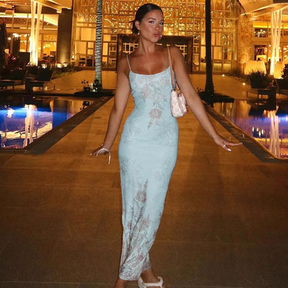 Woman wearing Orchid Moda frozen allure formal gown in light blue with floral lace details outdoors at night