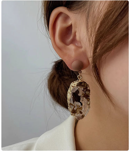 Trendy stone earrings for women featuring natural stone and gold accents worn on ear