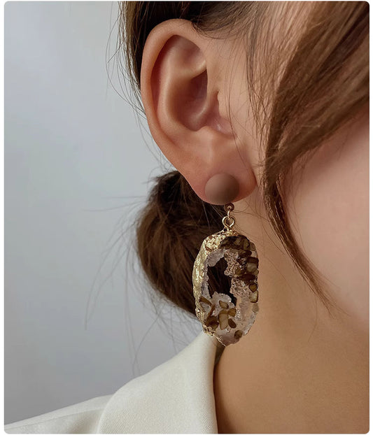Trendy stone earrings for women featuring natural stone and gold accents worn on ear