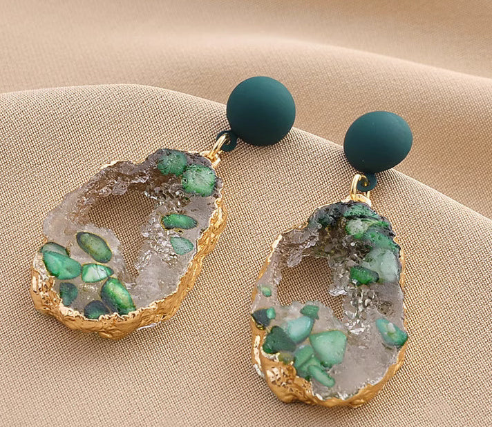 Orchid Moda trendy stone earrings for women with green stones and gold trim on beige fabric