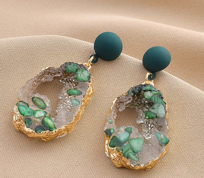 Orchid Moda trendy stone earrings for women with green stones and gold trim on beige fabric