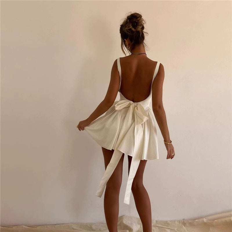 Back view of woman wearing a white knotted bow mini dress for women by Orchid Moda