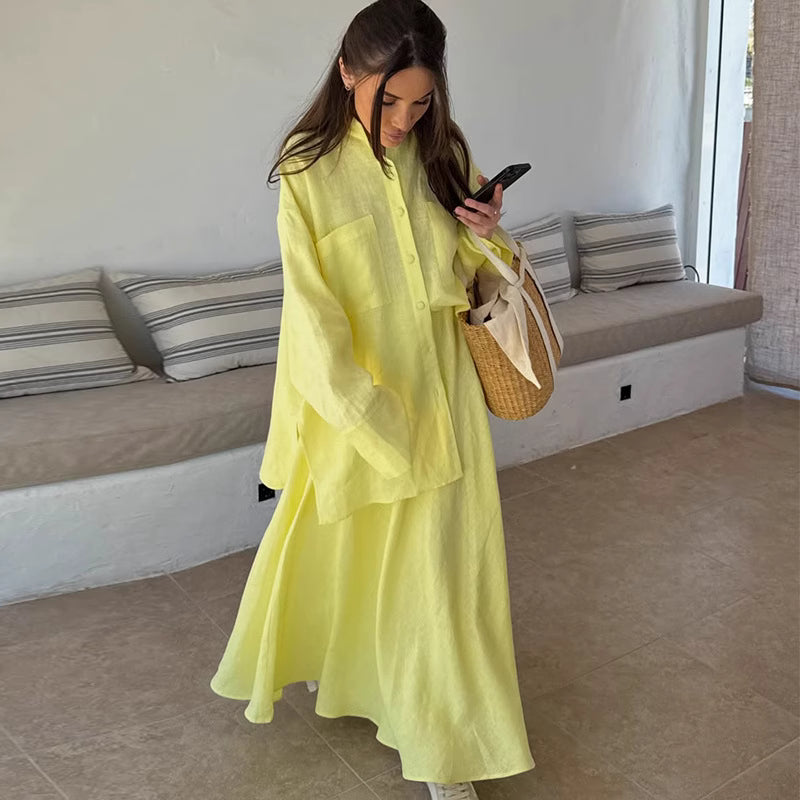 Woman wearing lemon yellow co ord set with oversized shirt and flowing skirt indoors
