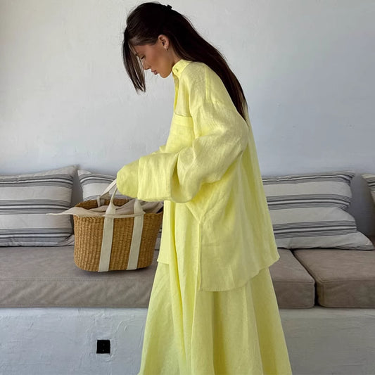 Woman wearing lemon yellow co ord set with long sleeves and loose fit holding woven bag indoors