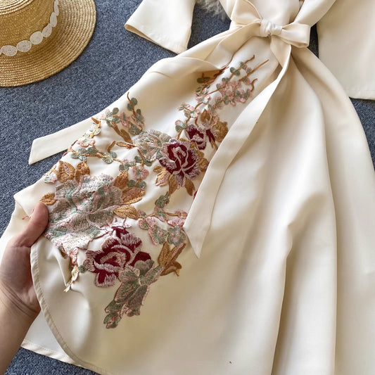 Close-up of almondine midi dress by Orchid Moda showing detailed floral embroidery and tied waist design