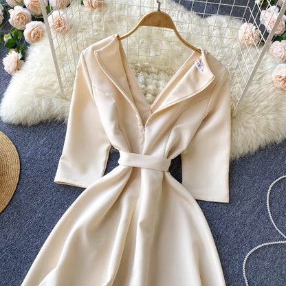 Orchid Moda almondine midi dress in cream with long sleeves and a belted waist on a hanger