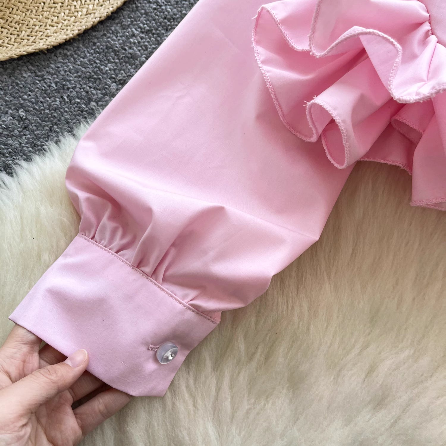 Close-up of ruffle rose pink shirt sleeve with button cuff worn by Orchid Moda