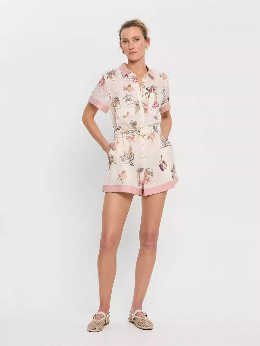 Orchid Moda short sleeve linen romper with floral print and pink trim worn by female model