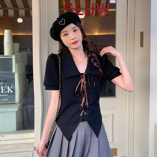 Orchid Moda black short sleeve statement shirt with lace-up front worn by woman in beret