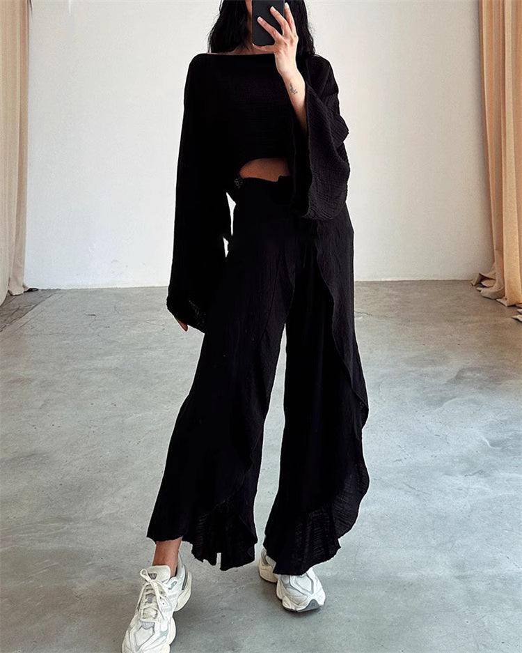 Woman wearing black split hem pants outfit for women paired with matching long sleeve top and white sneakers