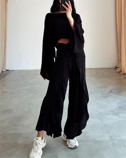 Woman wearing black split hem pants outfit for women paired with matching long sleeve top and white sneakers