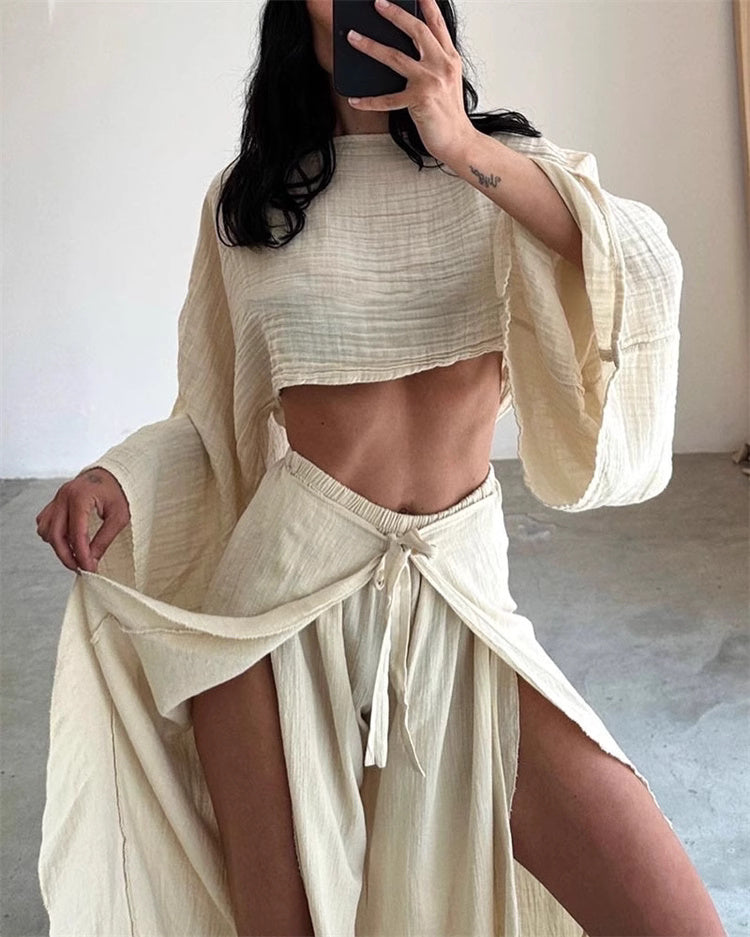 Woman wearing beige split hem pants outfit for women with a matching crop top and flowing sleeves