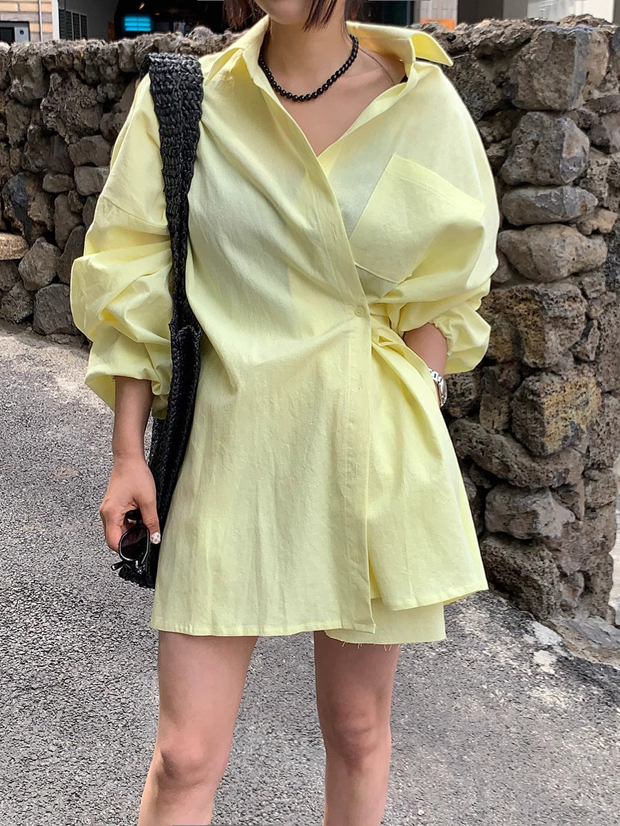 Woman wearing a yellow oversized shirt dress with a black necklace and bag in a sunkissed summer outfit for women