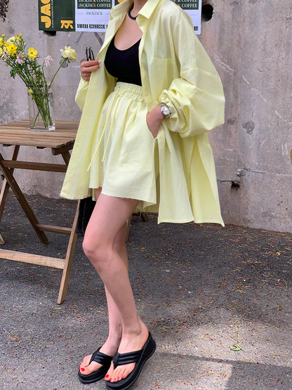 Woman wearing Orchid Moda yellow loose shirt and shorts pairing black top and sandals sunkissed summer outfit for women