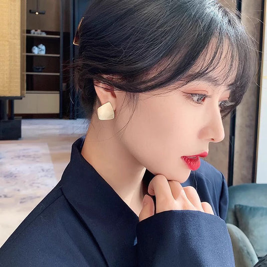 Orchid Moda trendy geometric earrings for women worn by a woman with short black hair and red lipstick