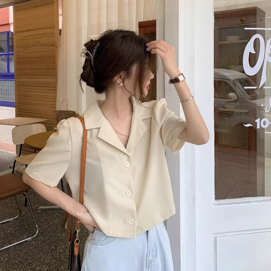 Trendy short sleeved shirt women in beige with buttons worn casually by woman with hair clip