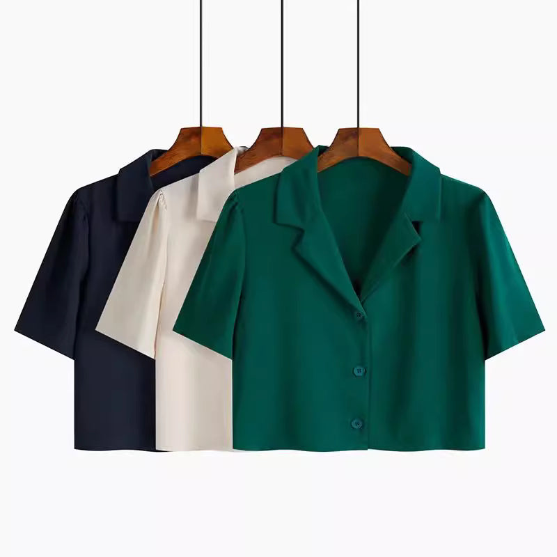 Trendy short sleeved shirt women in green, beige, and black colors hanging on wooden hangers