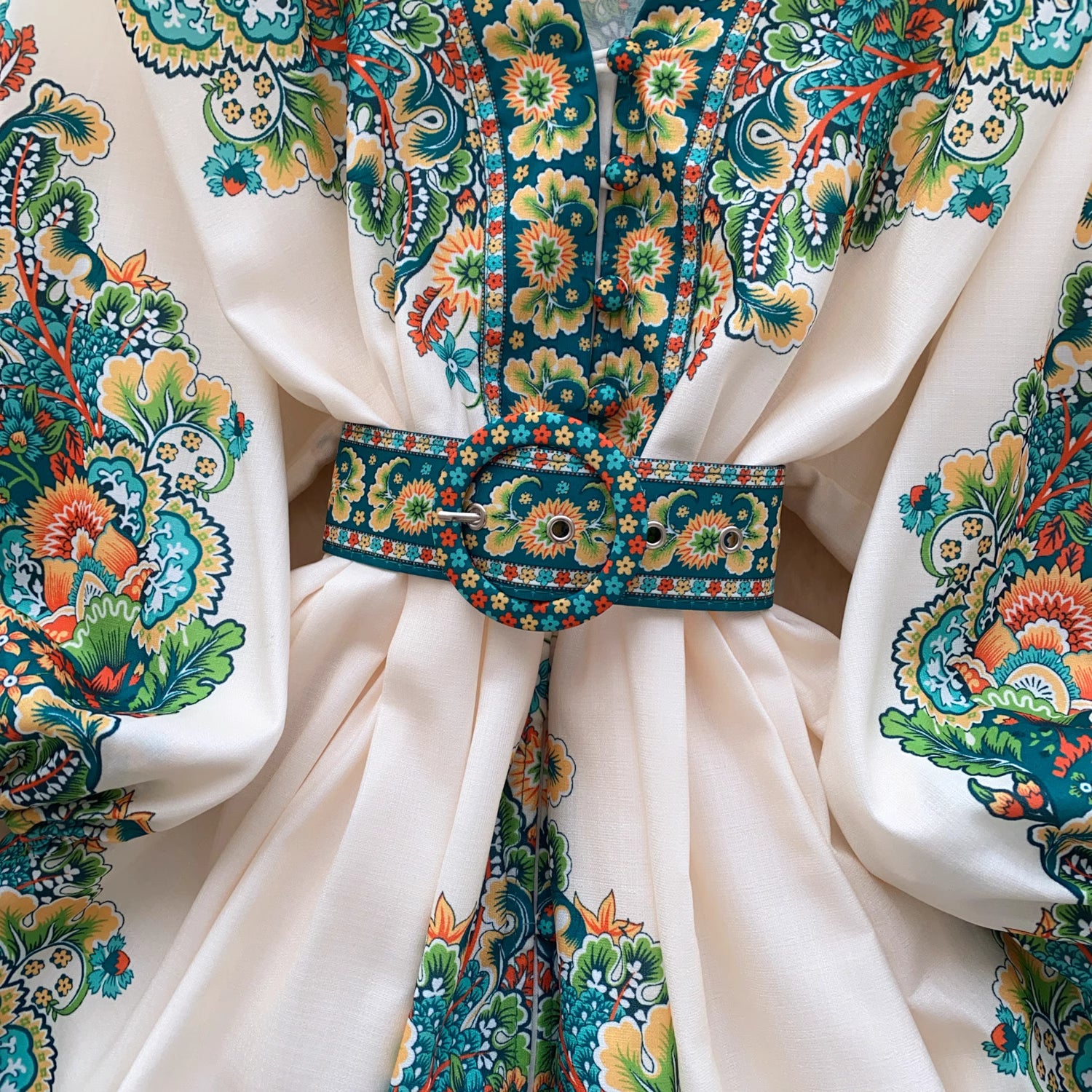 Close-up of colorful floral patterned fabric with a matching belt on a trendy weekender dress for women
