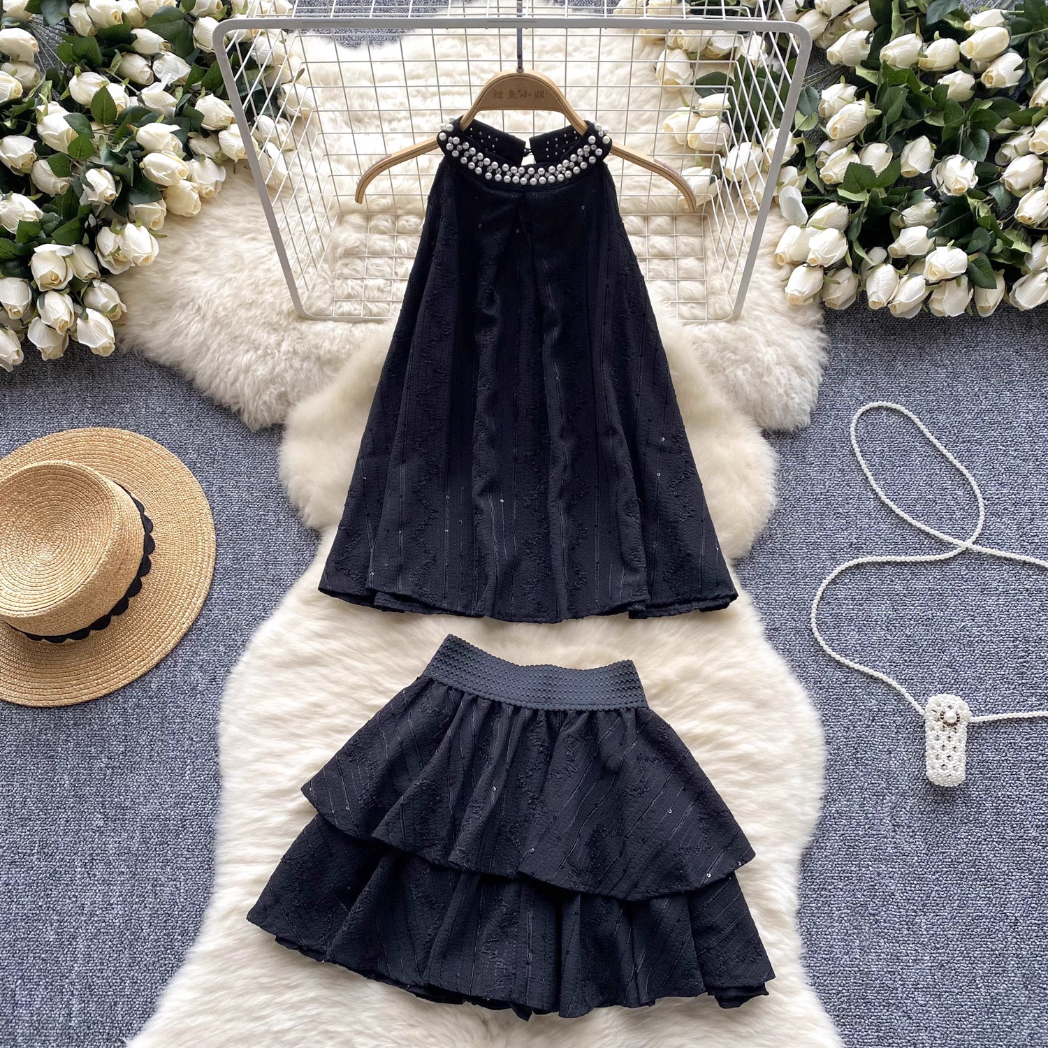 Black beaded co ord set for women with sleeveless top and layered skirt displayed on white fur rug
