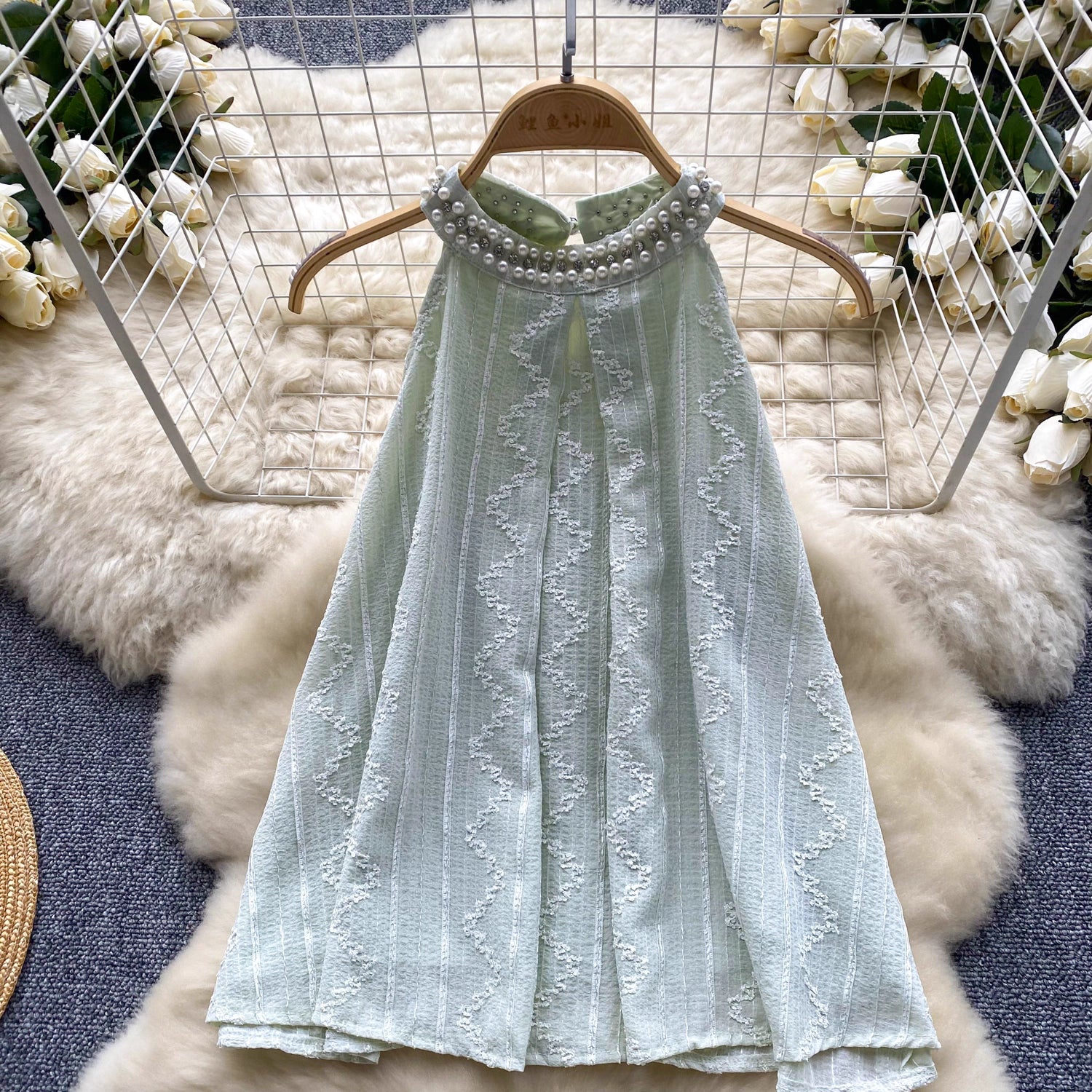 Light green beaded co ord set for women with pearl neckline detail hanging on wooden hanger