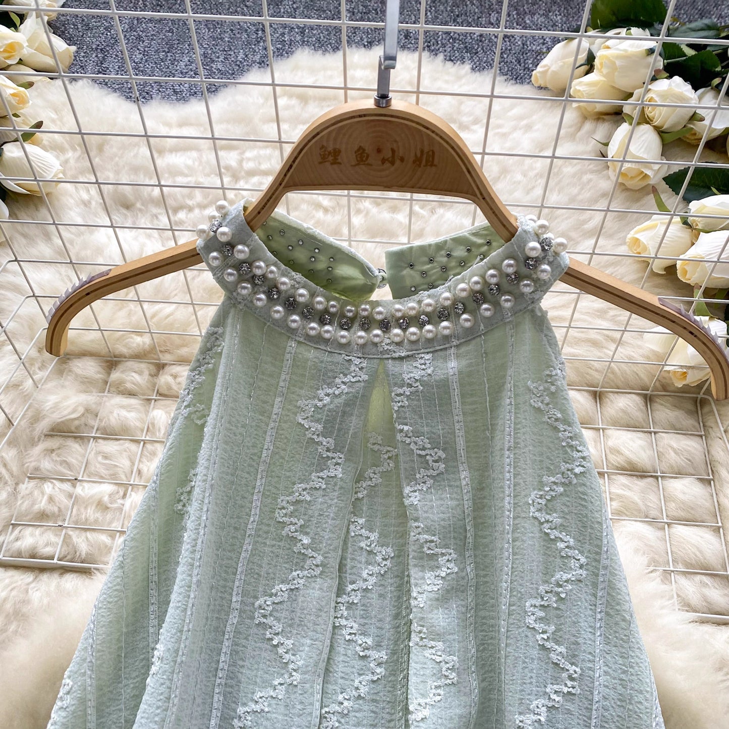 Close-up of a light green beaded co ord set for women with pearl embellishments on the collar