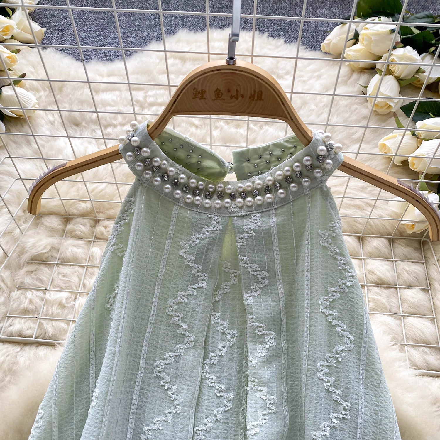 Close-up of a light green beaded co ord set for women with pearl embellishments on the collar