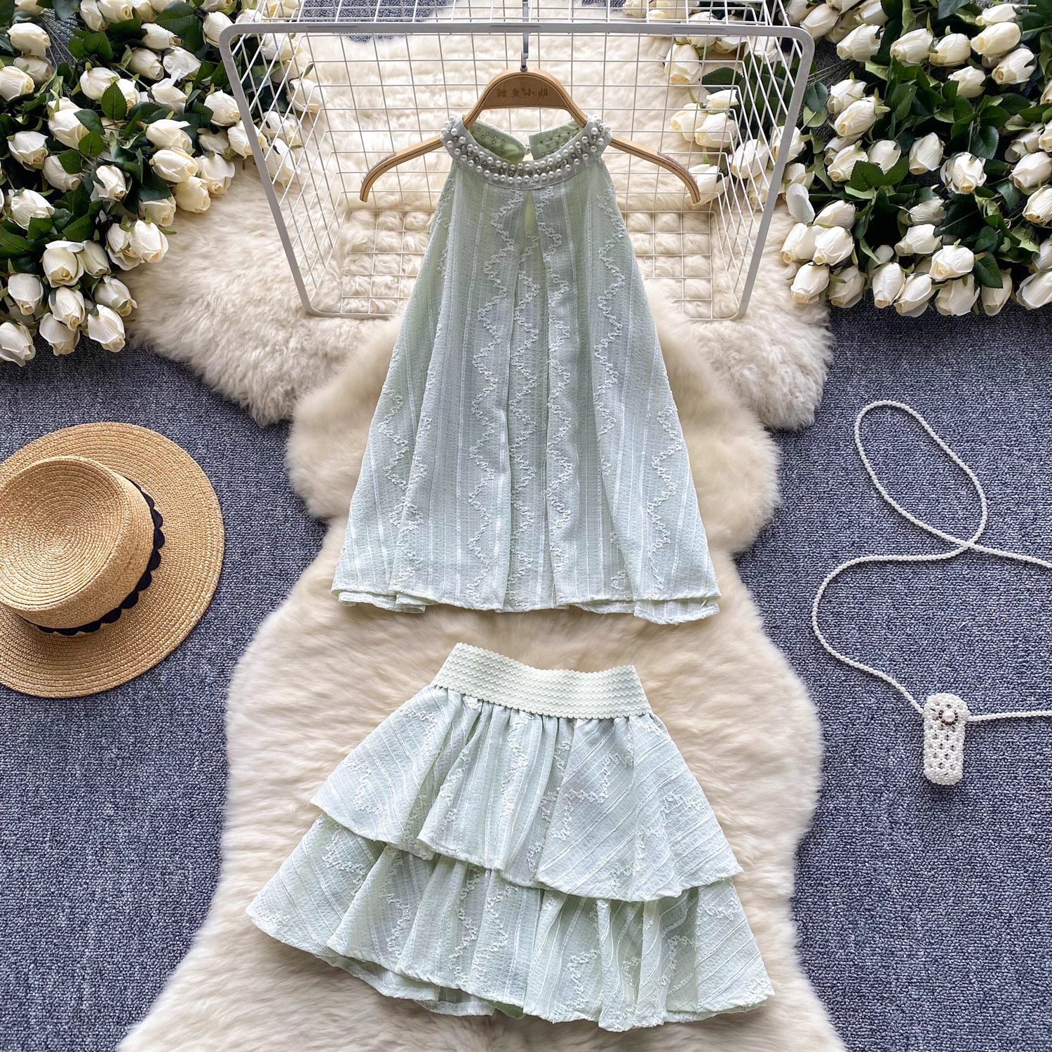Orchid Moda light green beaded co ord set for women with halter top and tiered skirt on fur rug