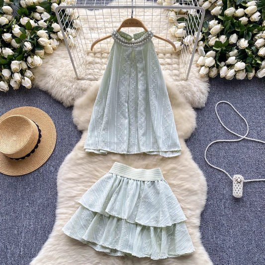 Orchid Moda light green beaded co ord set for women with halter top and tiered skirt on fur rug