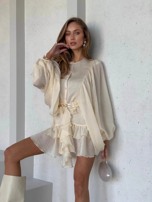 Orchid Moda elegant lantern sleeve dress in cream with ruffle details and gold belt accessory