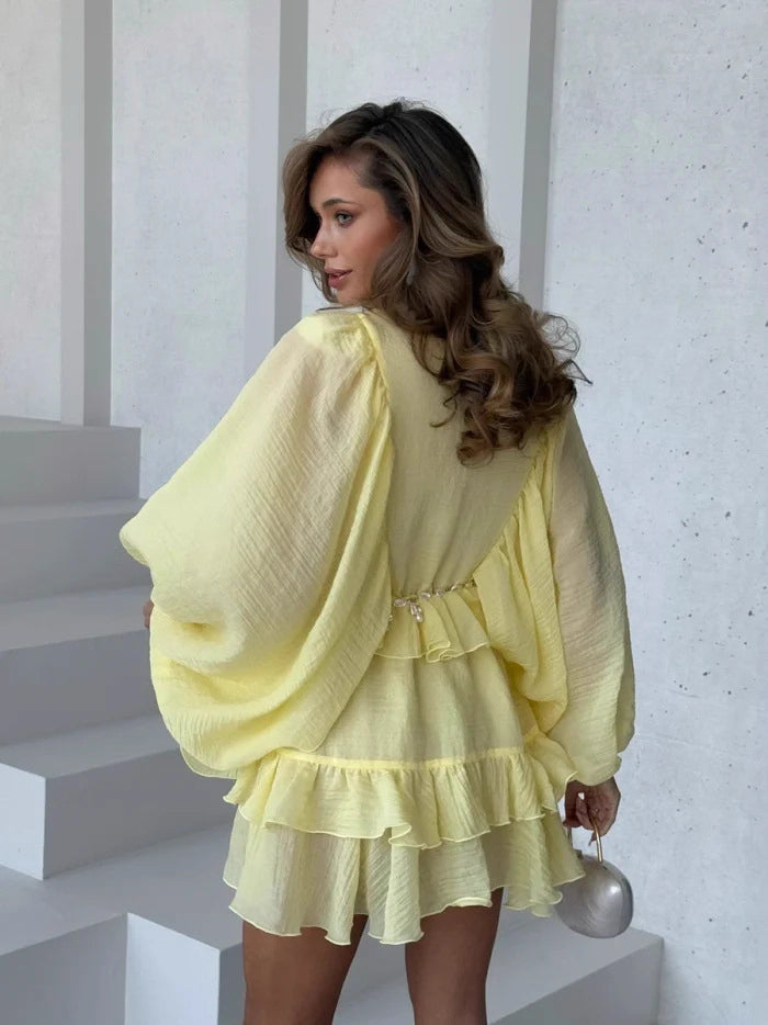 Orchid Moda elegant lantern sleeve dress in light yellow with ruffle hem and sheer fabric
