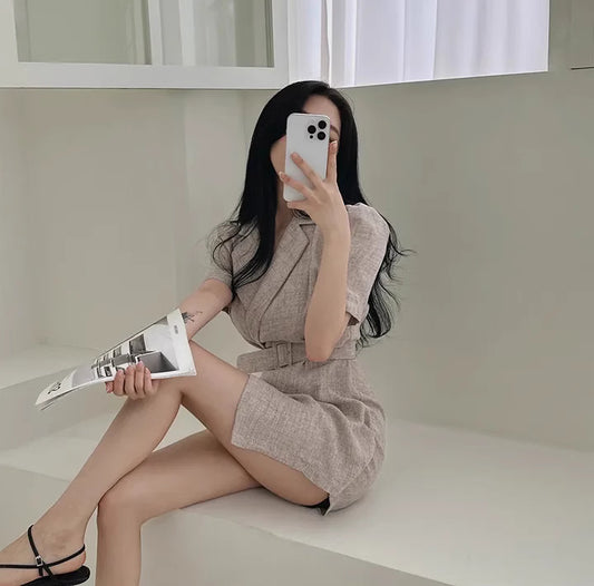 Petite Korean suit dress in beige with short sleeves and belt detail worn by seated woman
