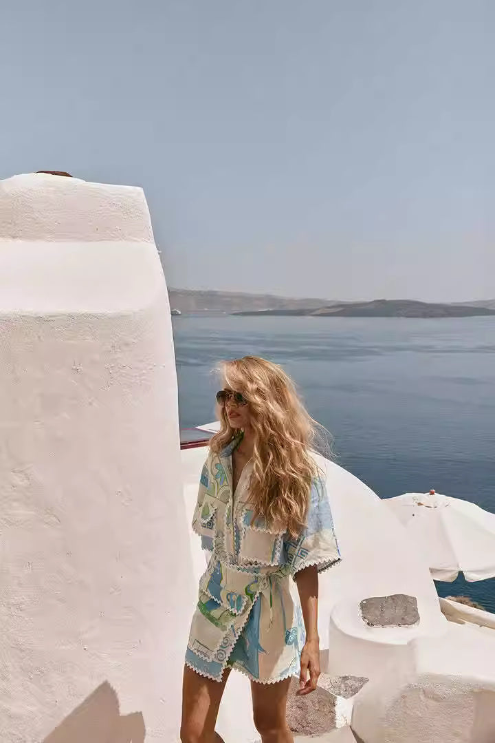 Woman wearing printed co-ord set for women with blue and beige patterns standing by white architecture near the sea