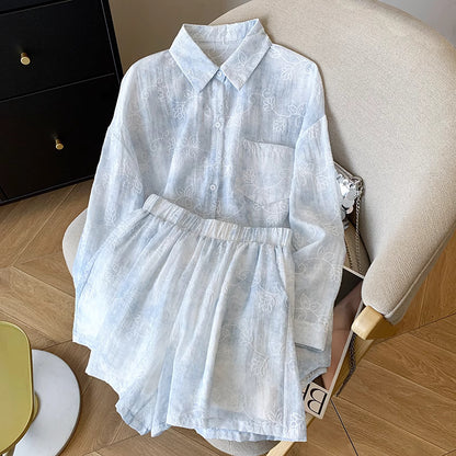 Light blue summer co-ord suit for women with floral patterns by Orchid Moda displayed on beige chair
