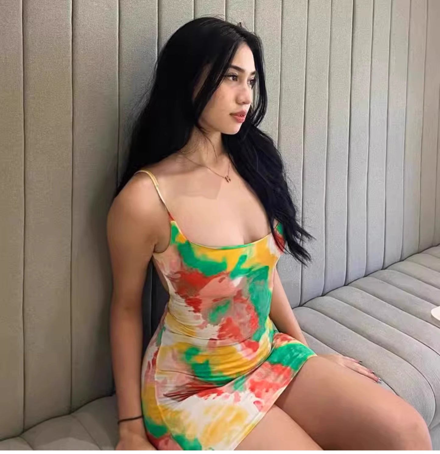 Orchid Moda watermelon print bodycon dress worn by woman sitting on gray couch with long black hair